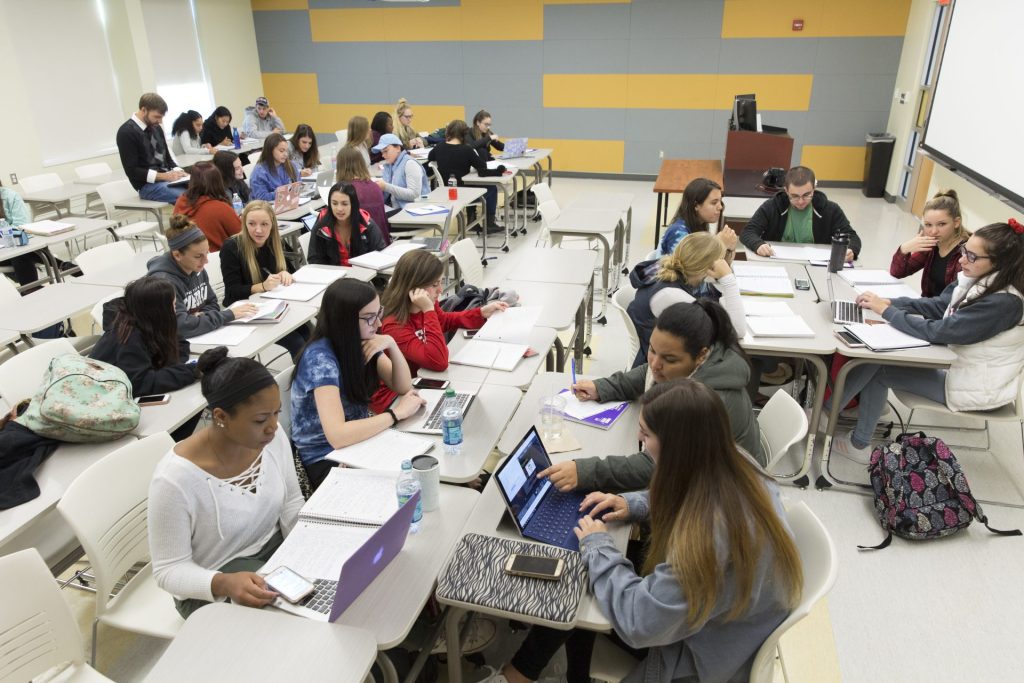 SUNY Oneonta students work at their desks in a classroom.
