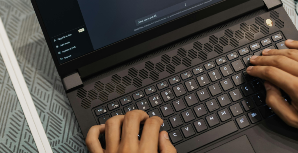 Two hands typing on a laptop keyboard, viewed from above